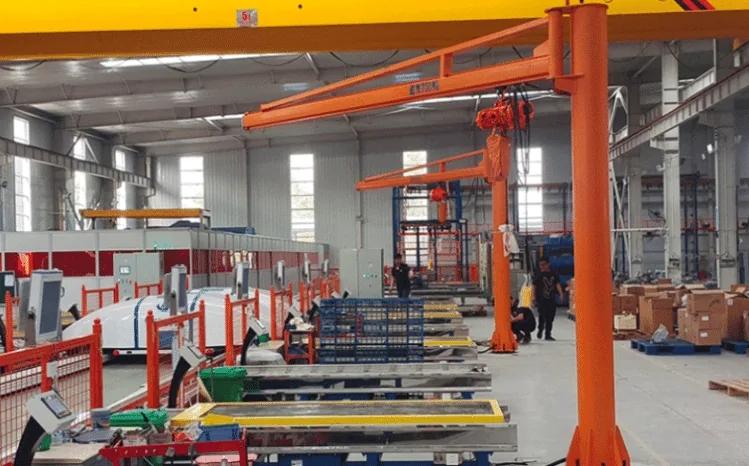 Orange floor mounted pillar jib crane with chain hoist in a production hall