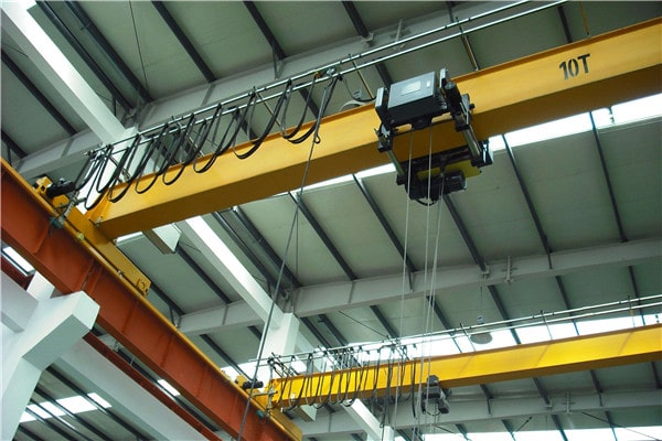 Top‑running overhead crane mounted on building runway beams for heavy‑load production