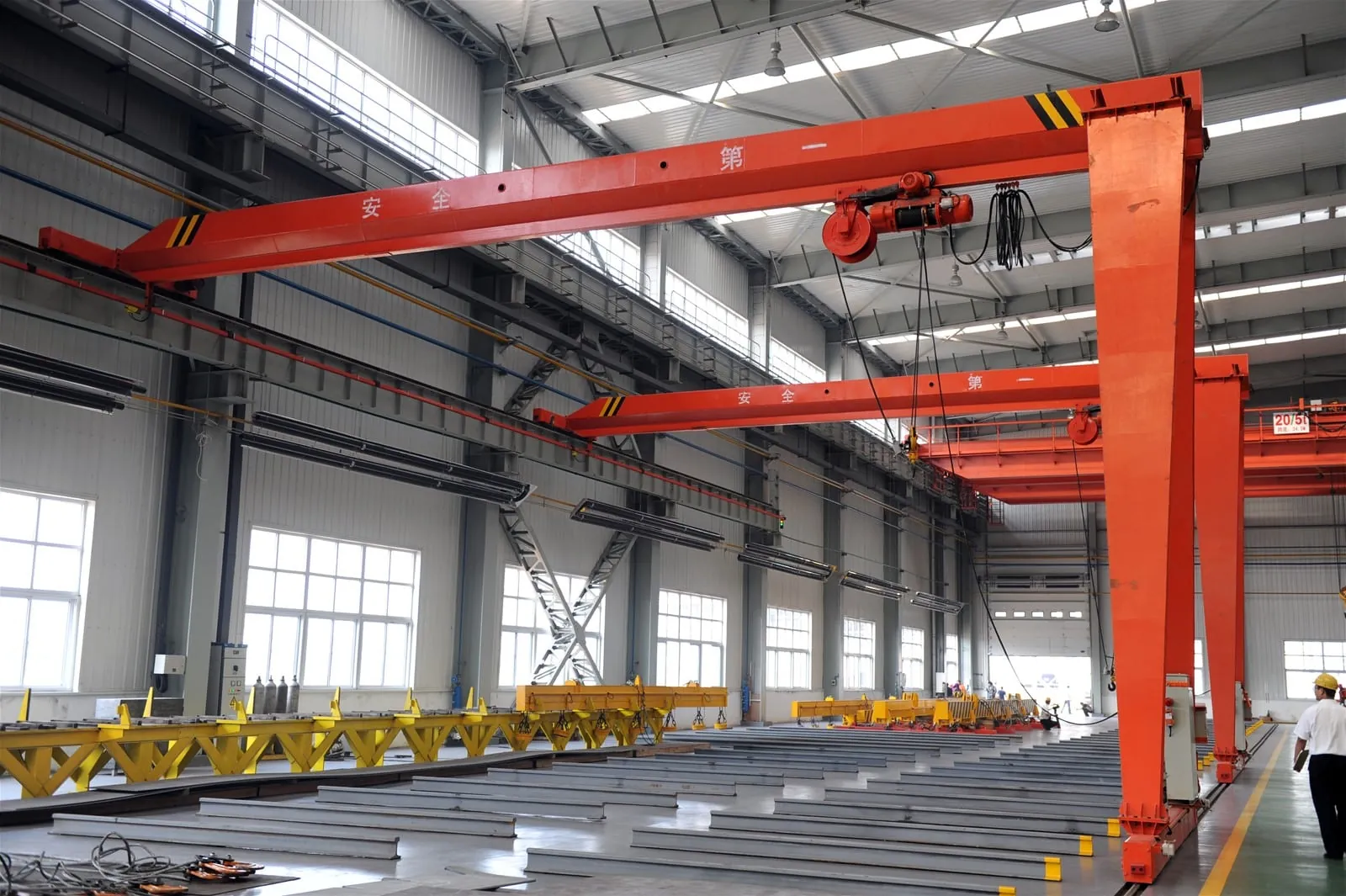 Semi gantry cranes running on a ground rail inside a workshop