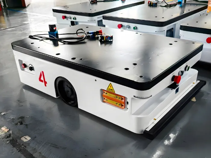 Compact platform AGV with a black load deck, emergency stop and side charging contacts
