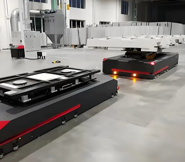 Two heavy-duty AGVs carrying machine frames on top-mounted locating fixtures