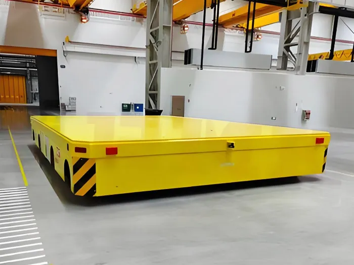 Low-profile trackless transfer cart with multiple wheel sets on a workshop floor