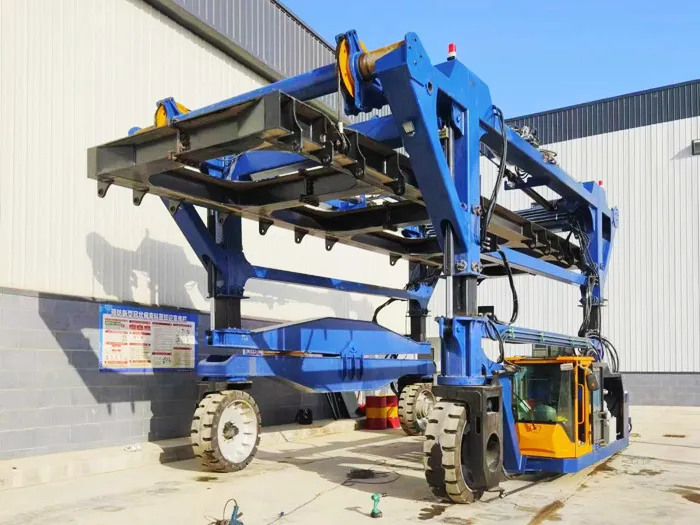 Mobile energy storage straddle carrier with operator's cab and rigid lifting frame, side view