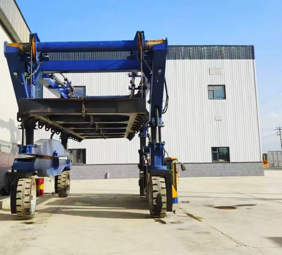 Mobile energy storage straddle carrier seen from the end, showing the lifting frame between the legs
